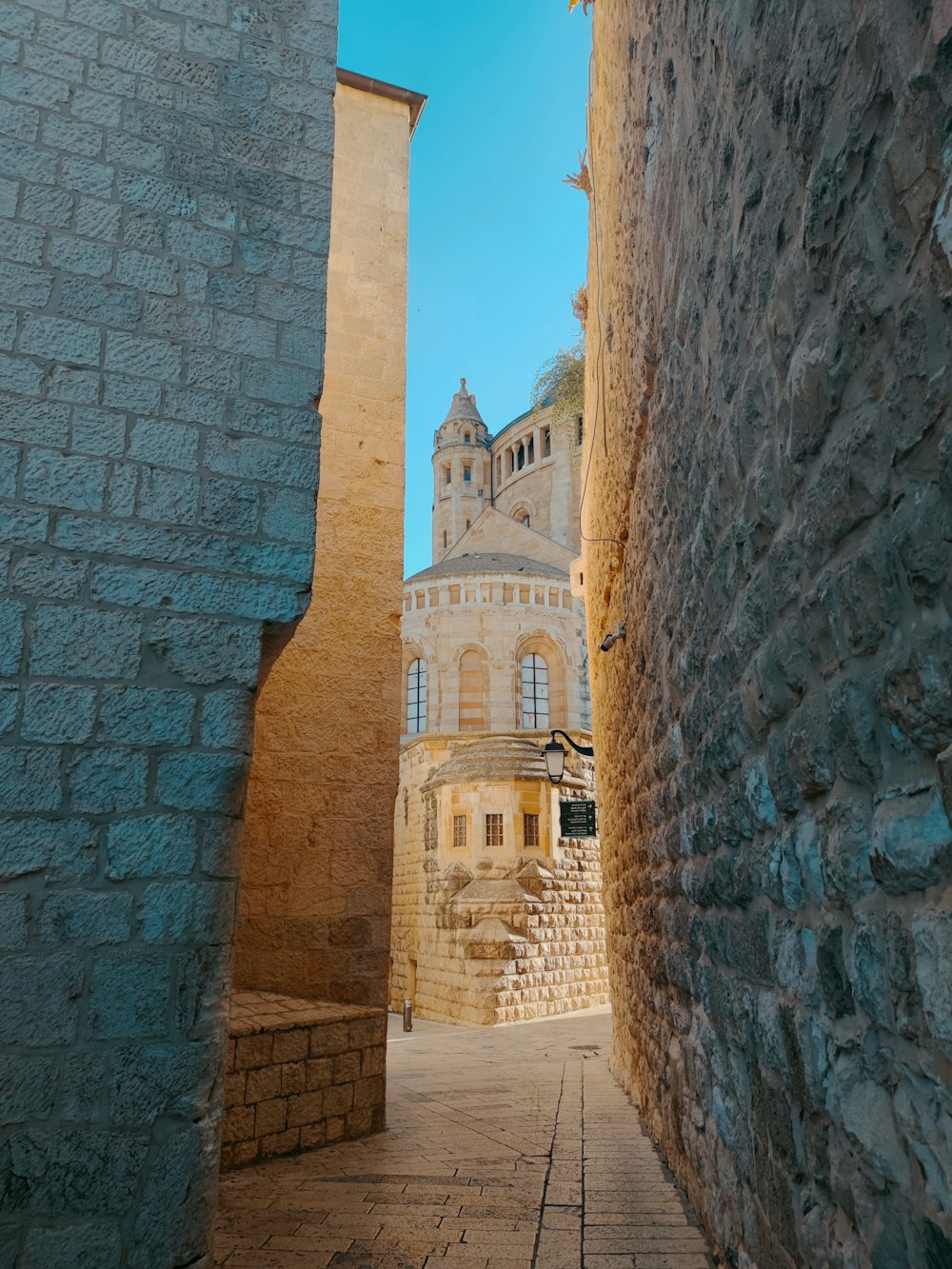 a stone walkway between two stone buildings