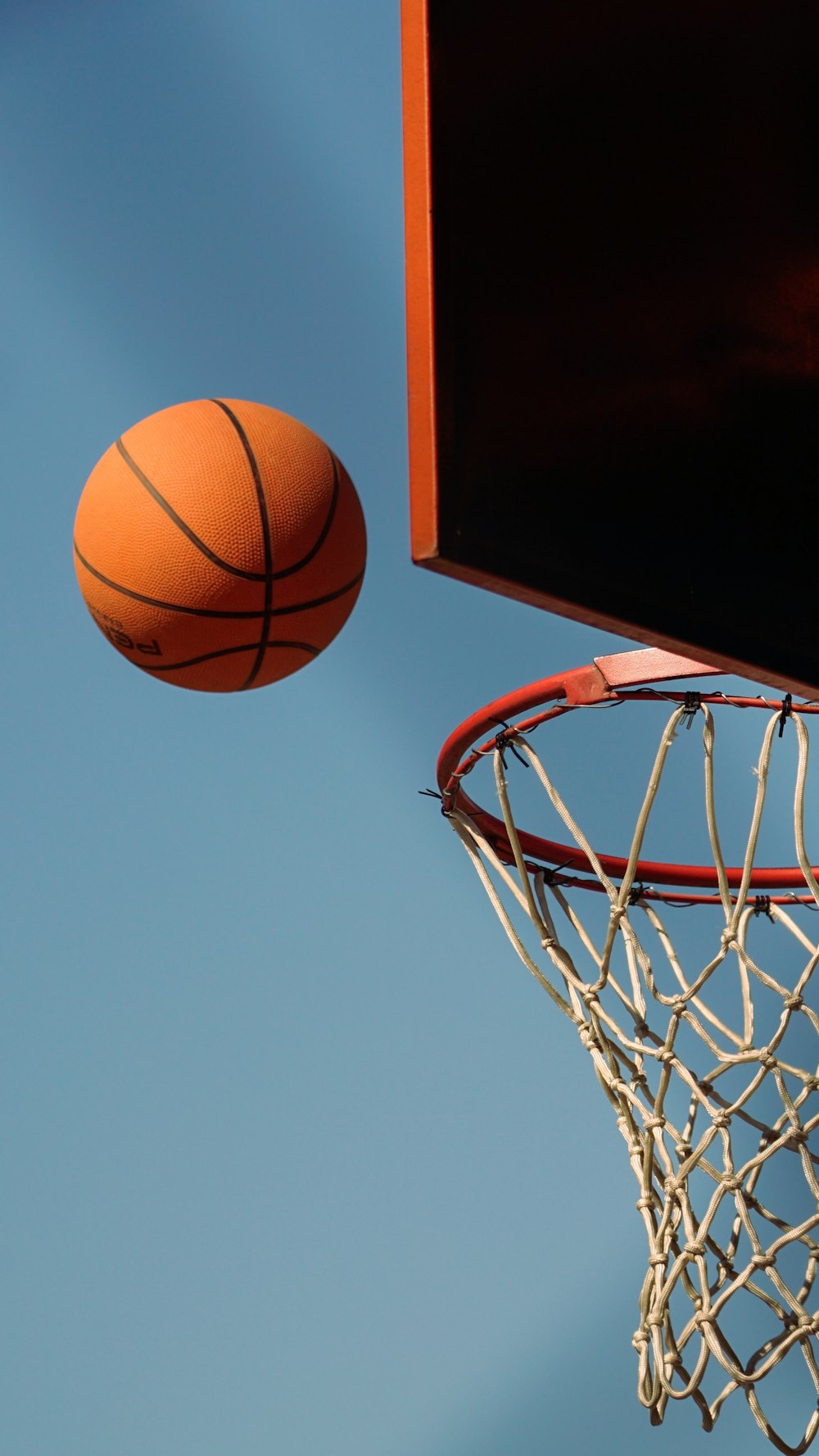 Un aro de baloncesto con una pelota en el aire