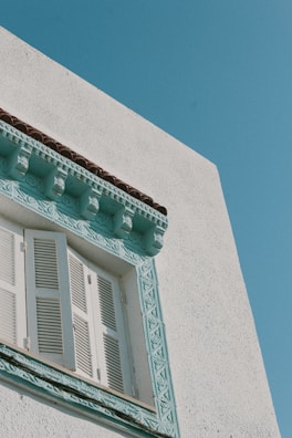 Close-up of architectural details showcasing crisp white walls and blue window frames.