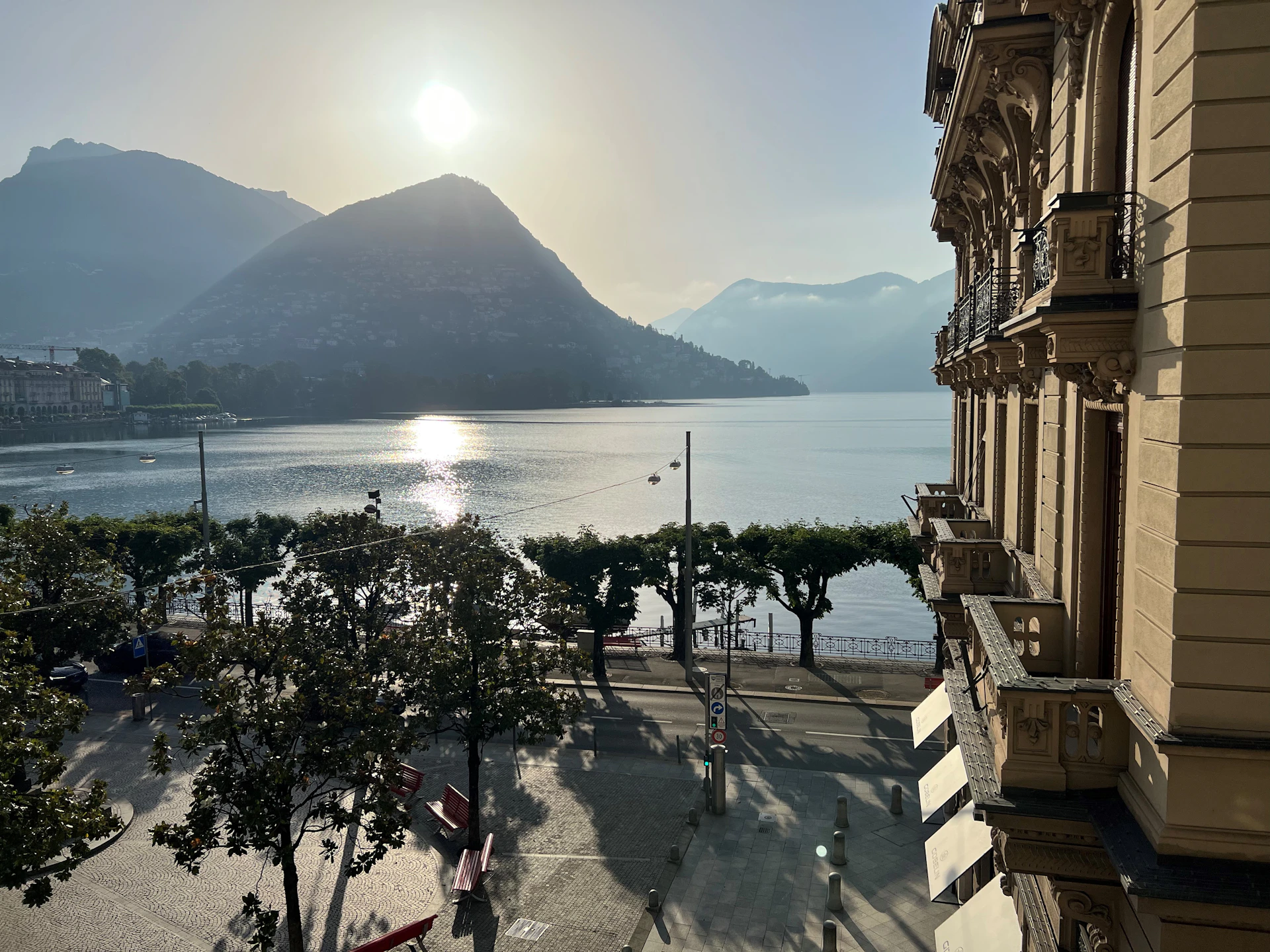 A serene early morning view of the waterfront from the lodge balcony, with soft sunlight reflecting on calm waters.