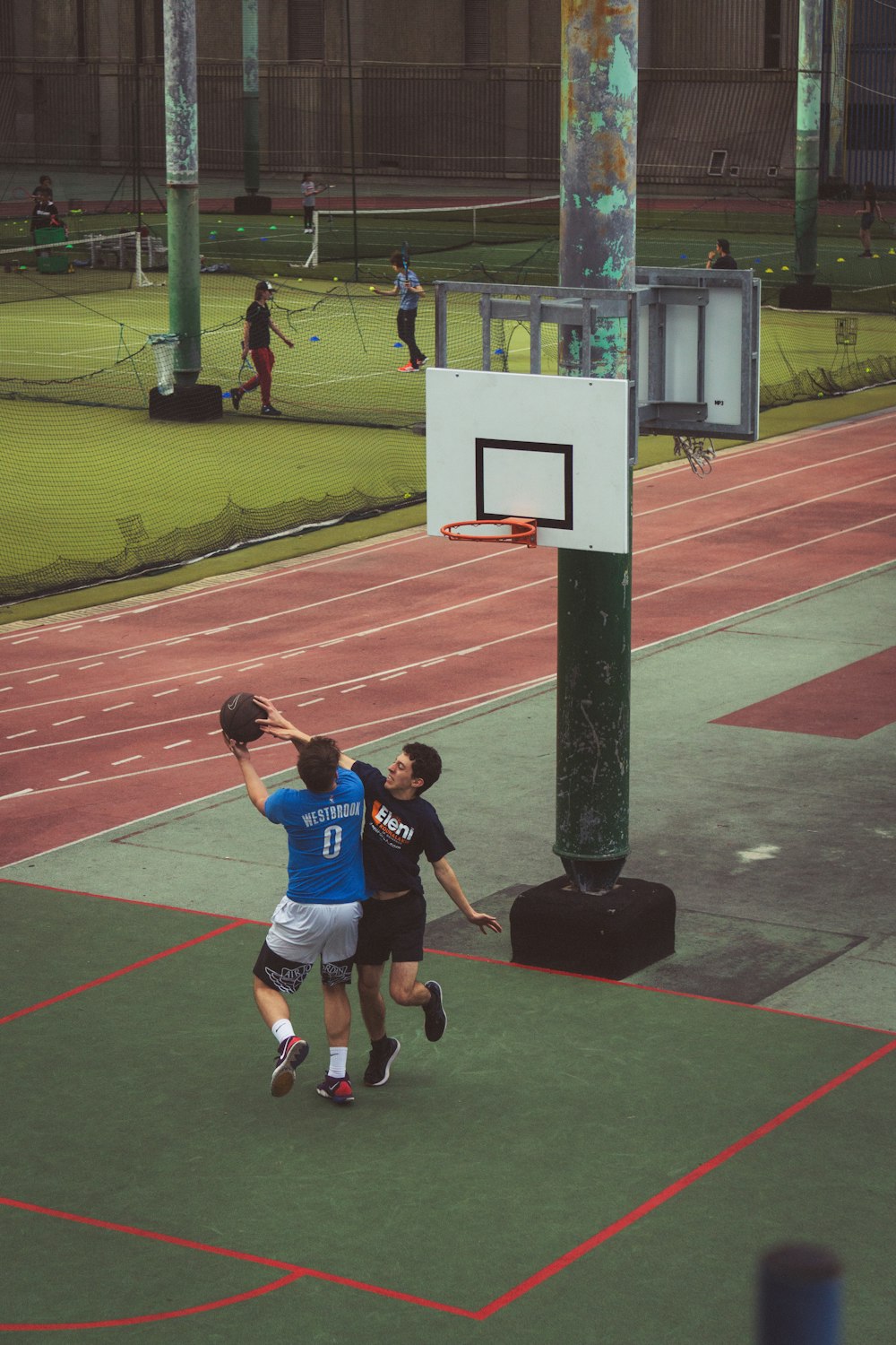 a couple of people playing basketball