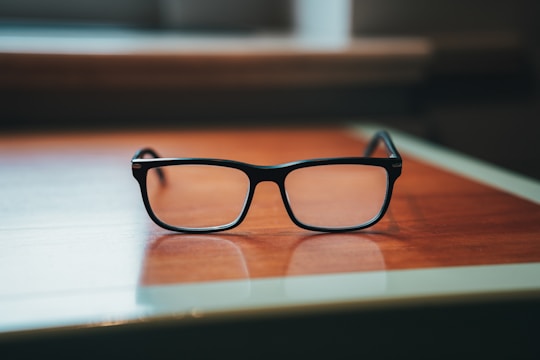 Close-up of high-end eyeglasses displayed on a wooden table.