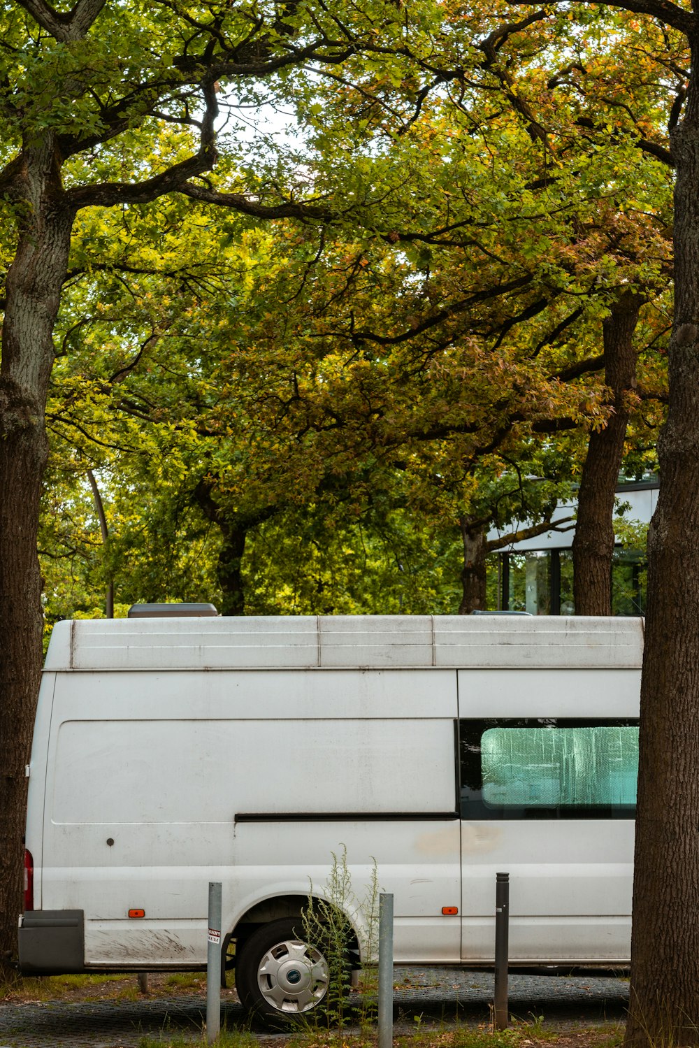 Ein weißer Wohnwagen, der unter Bäumen geparkt ist