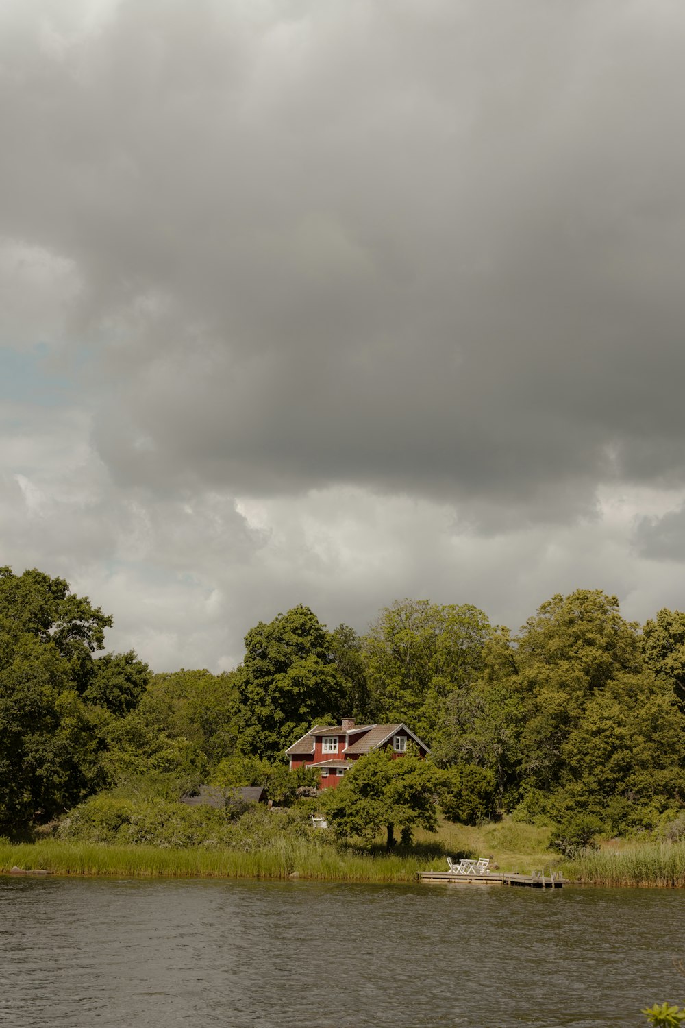 uma casa em uma colina à beira de um lago