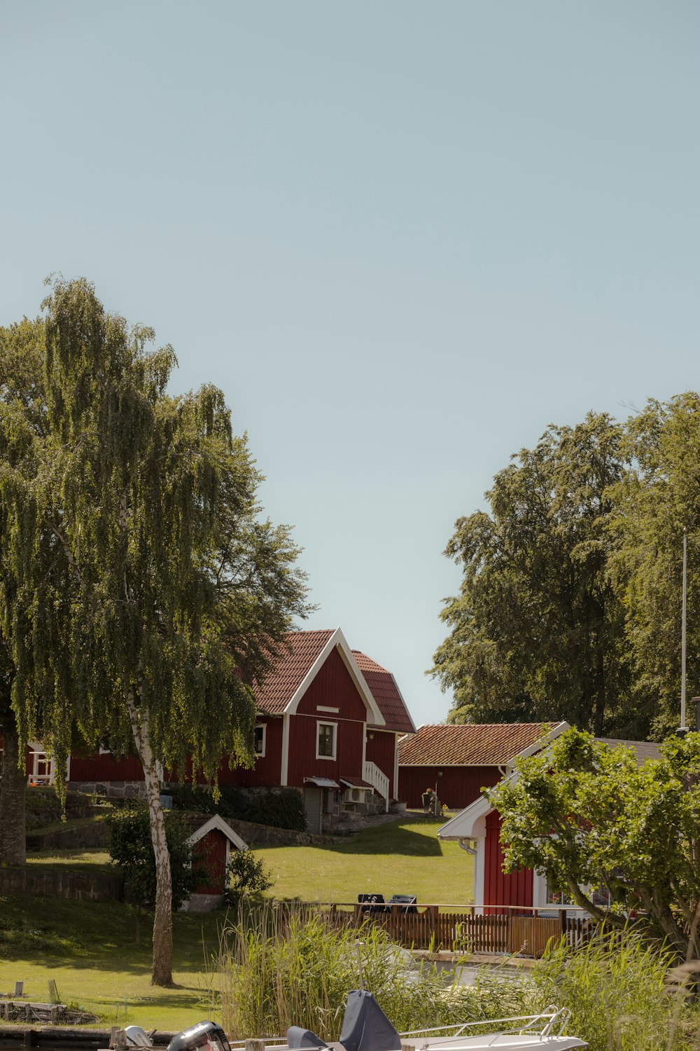 a red house with a fence and trees in the front