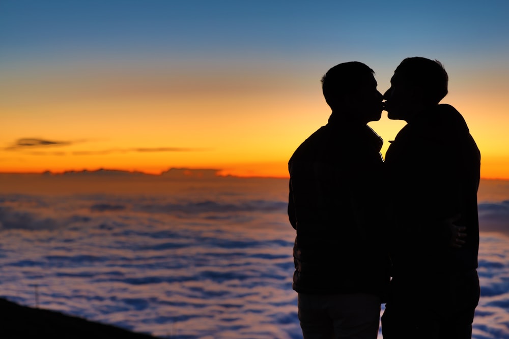 um par de pessoas olhando para o pôr do sol