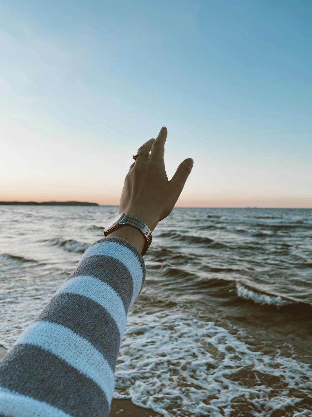 a person's hand on a beach