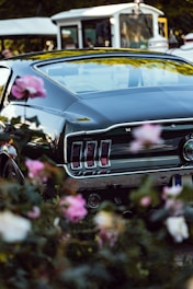 A classic vintage car surrounded by flowers at a photo shoot.