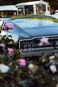 A classic vintage car surrounded by flowers at a photo shoot.