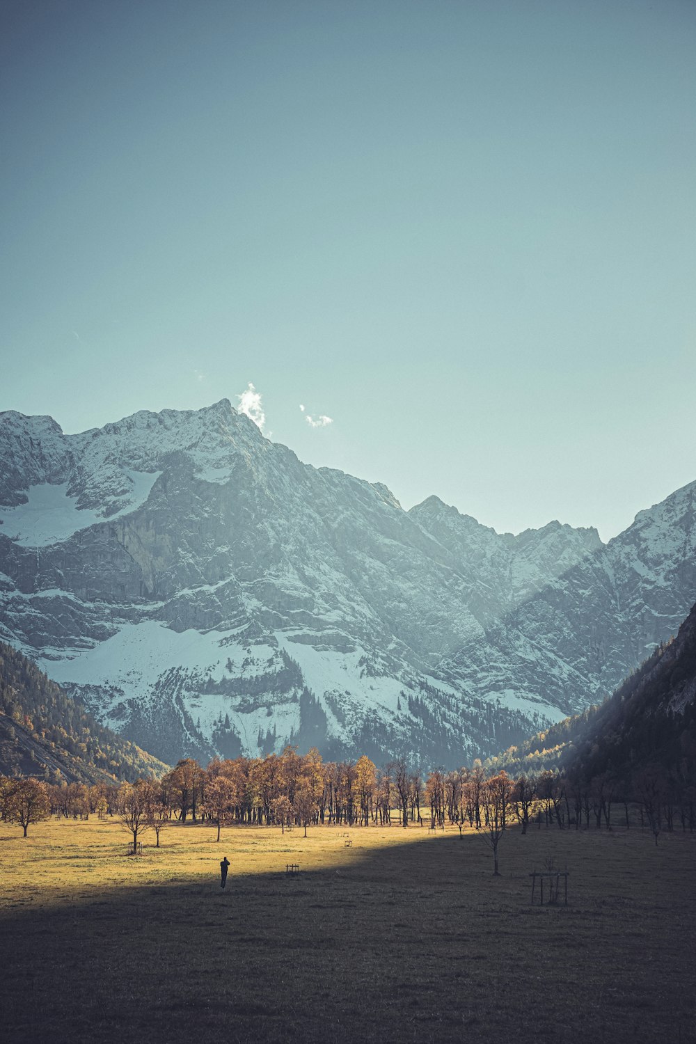 a person walking on a road in front of a mountain