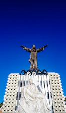a statue of a person holding a cross