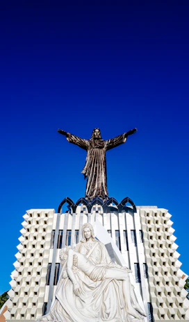 a statue of a person holding a cross