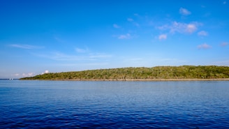 A serene view of the Mediterranean coastline with vibrant blue waters and sunny skies.