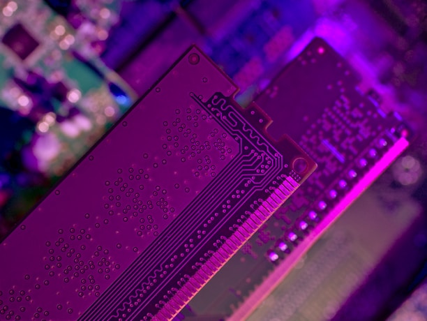 Technician carefully repairing a computer motherboard with blue ambient lighting