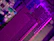 Close-up of a high-end gaming motherboard illuminated by neon purple lighting.