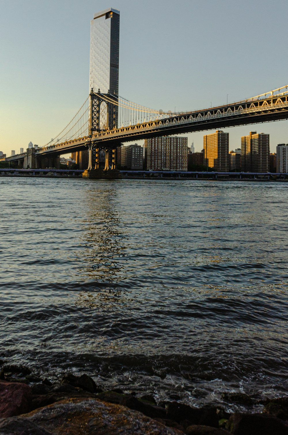 a bridge over water with a city in the background