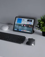 A neat desk setup featuring a tablet with social media branding visuals.
