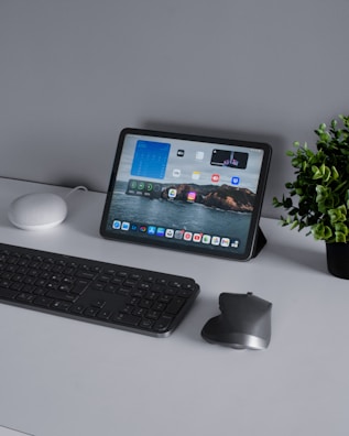 A neat desk setup featuring a tablet displaying a financial spreadsheet.