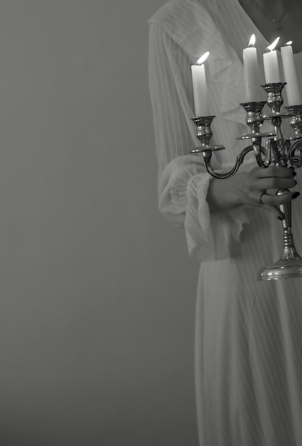 a person in a white dress holding a light fixture