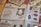 An array of identification documents is spread out. The prominent item in the center is an identity card from a fictional organization named 'Ministry of Magic', featuring a photograph of a smiling person and various personal details. Other documents include fingerprints, currency notes, and tickets. The documents have a vintage and magical theme.