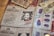 An array of identification documents is spread out. The prominent item in the center is an identity card from a fictional organization named 'Ministry of Magic', featuring a photograph of a smiling person and various personal details. Other documents include fingerprints, currency notes, and tickets. The documents have a vintage and magical theme.