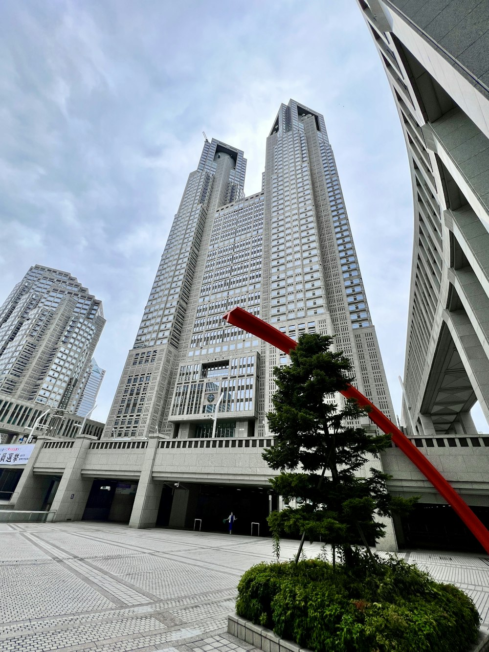 都市のビル群と建設クレーン