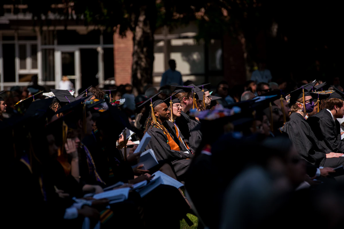 Groupe de jeunes diplômés en toges et chapeaux
