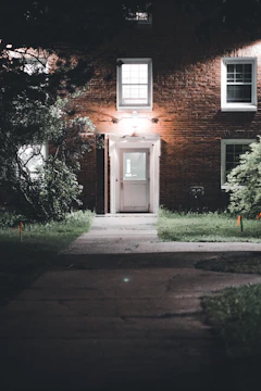 Outdoor security lights illuminating a business entrance at dusk.