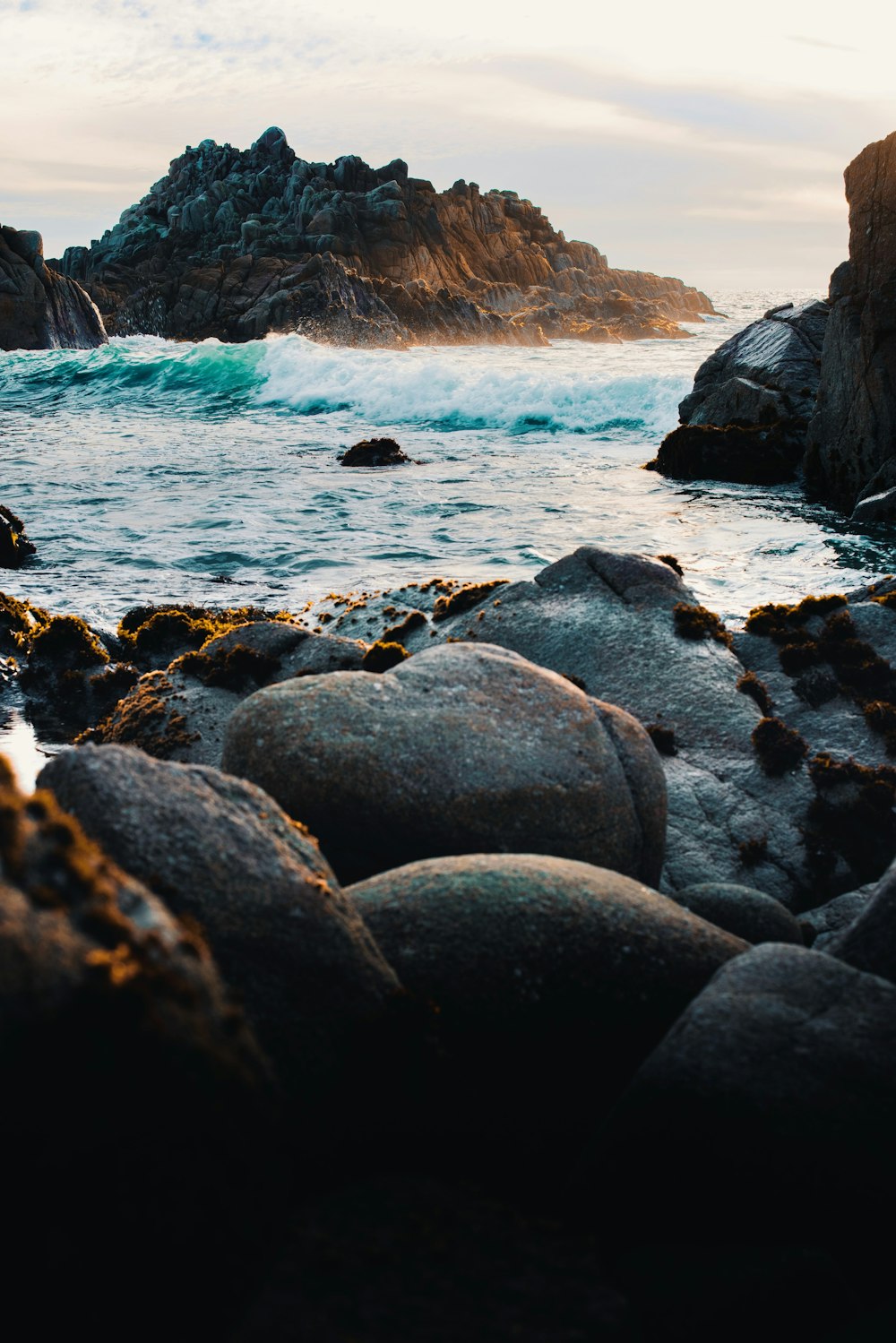 a rocky beach with a large body of water in the background