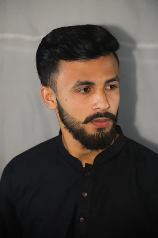 A close-up of a well-groomed bearded man in natural light, showcasing a confident and effortless grooming routine.