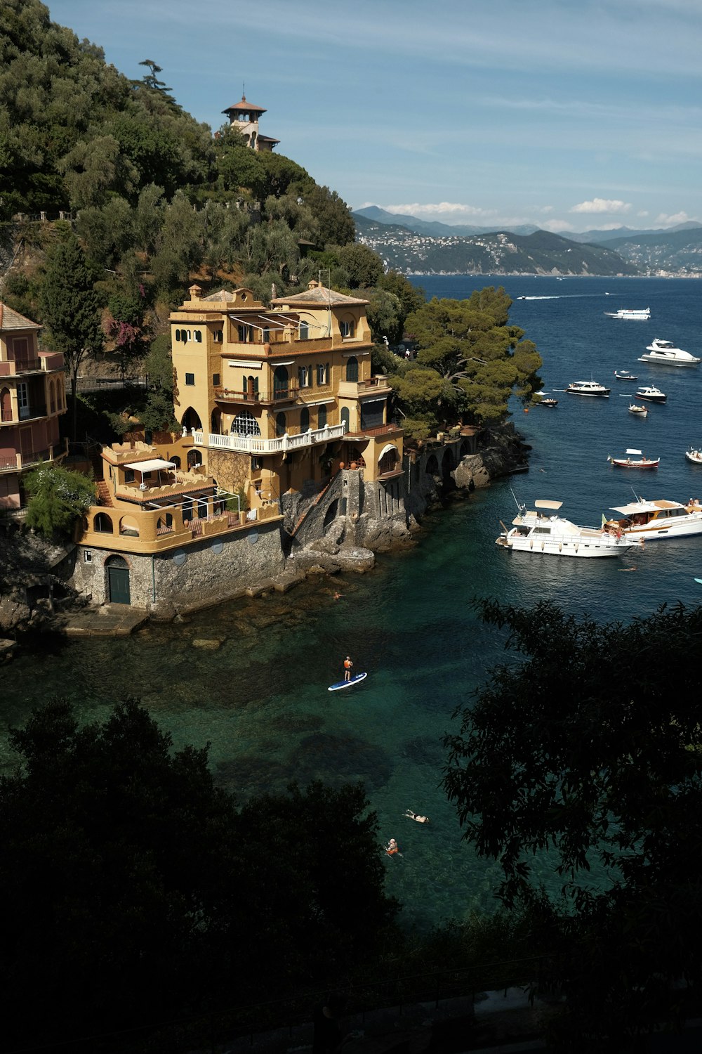 a building on a hill by the water with boats in the water