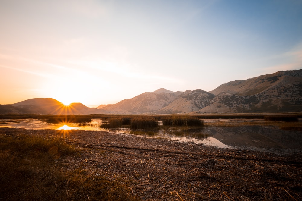 a body of water with mountains in the background