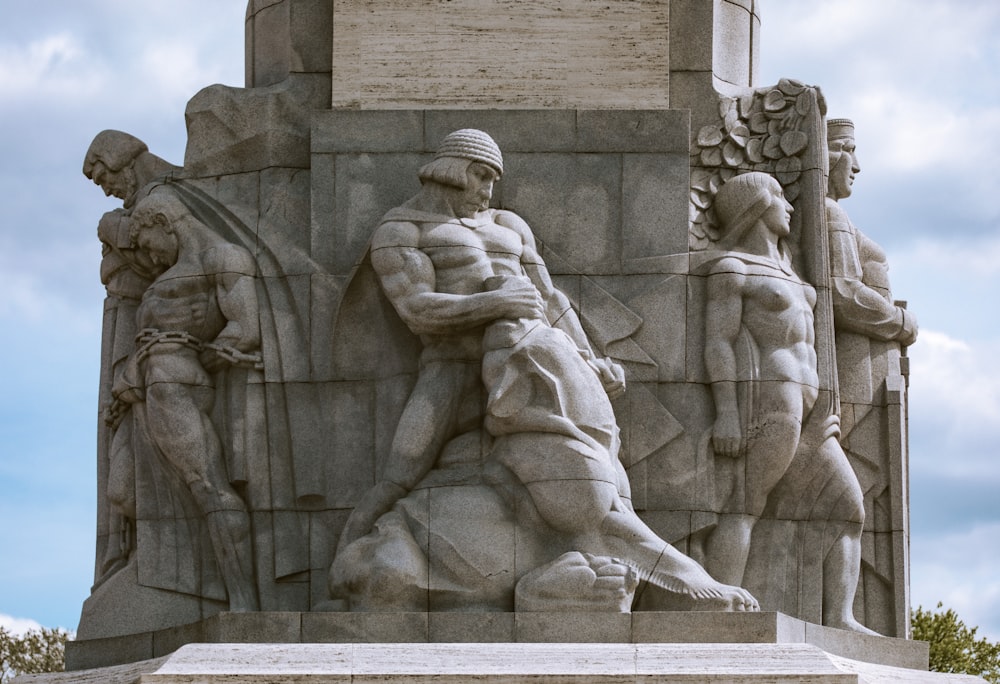 Un monumento de piedra con un grupo de personas en él