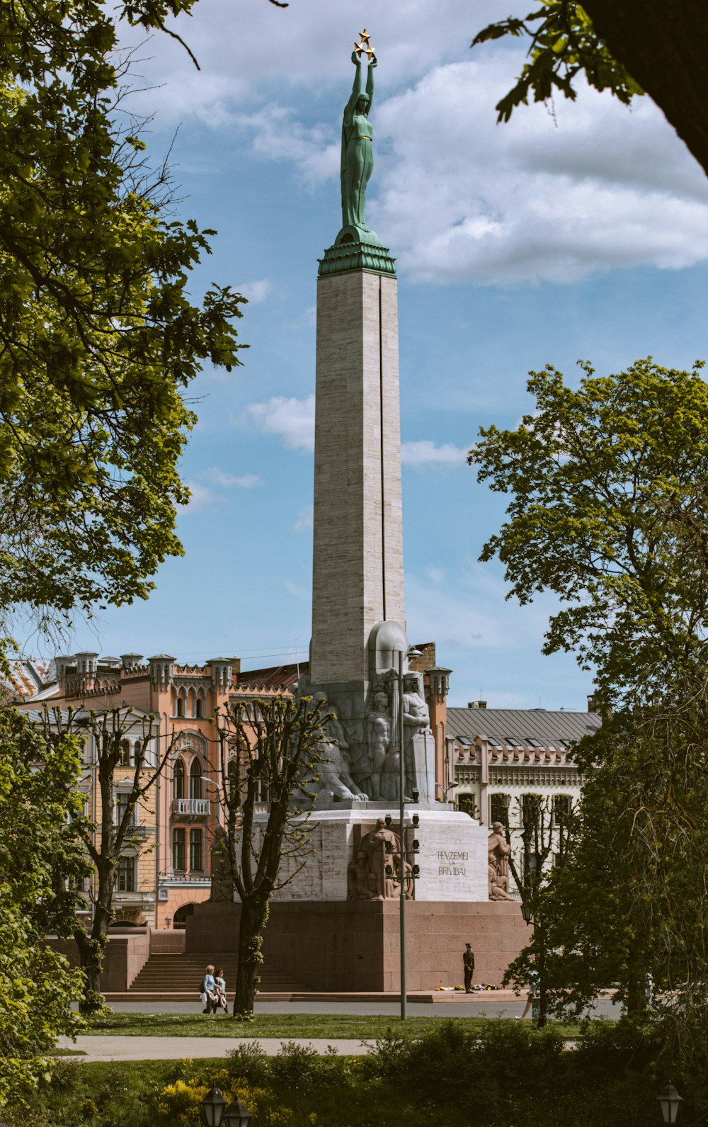 a statue of a person holding a torch in front of a building