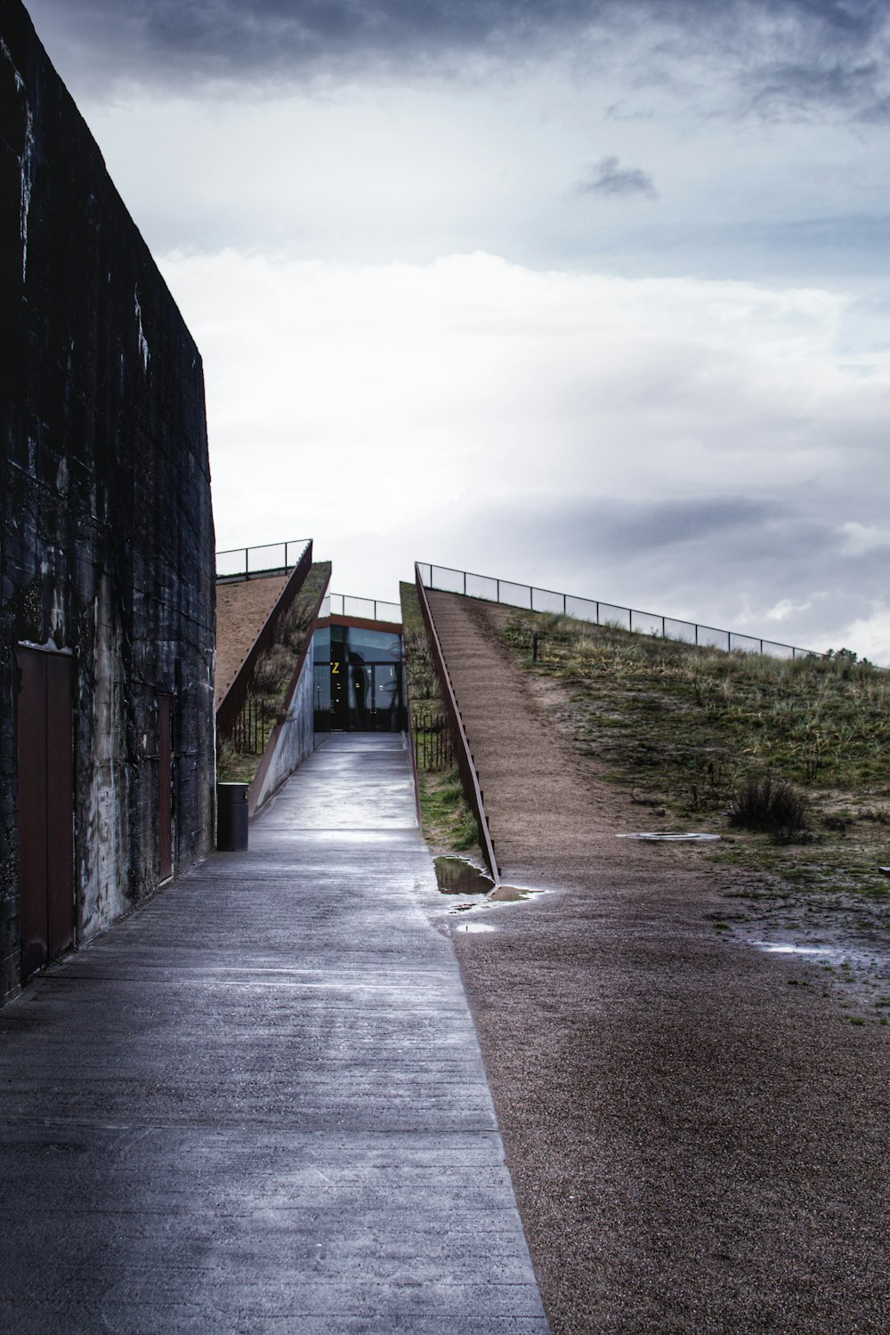 a path with a fence and grass on the side