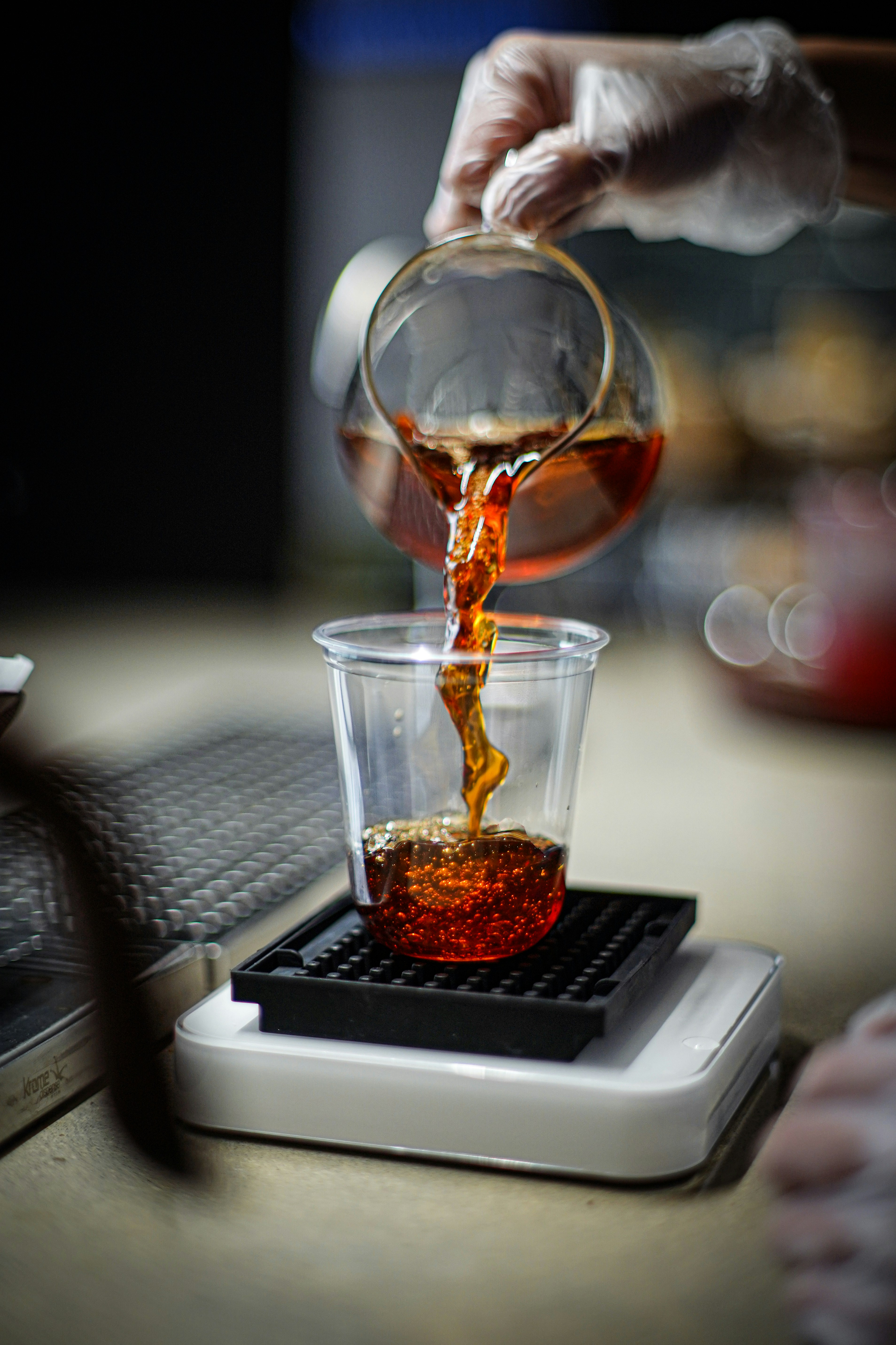 eine Hand, die eine Flüssigkeit in ein Glas gießt