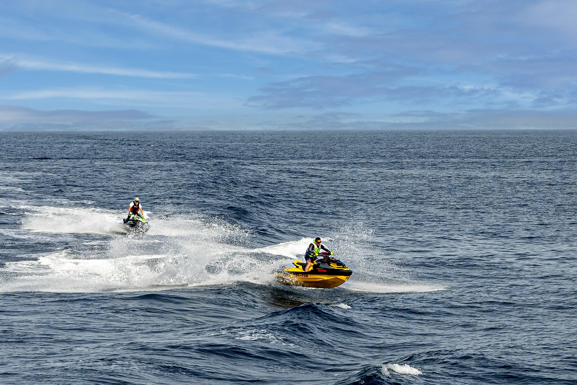 A thrilling jet ski adventure with friends speeding across the vibrant blue sea near Mandarmoni beach under a clear sky.