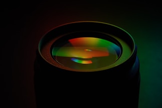 A moody, close-up shot of a camera lens reflecting a vibrant travel landscape