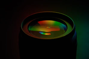 An artistic close-up of a camera lens reflecting a vivid outdoor scene during a shoot.