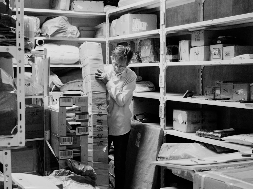 a person standing in a room with shelves and boxes