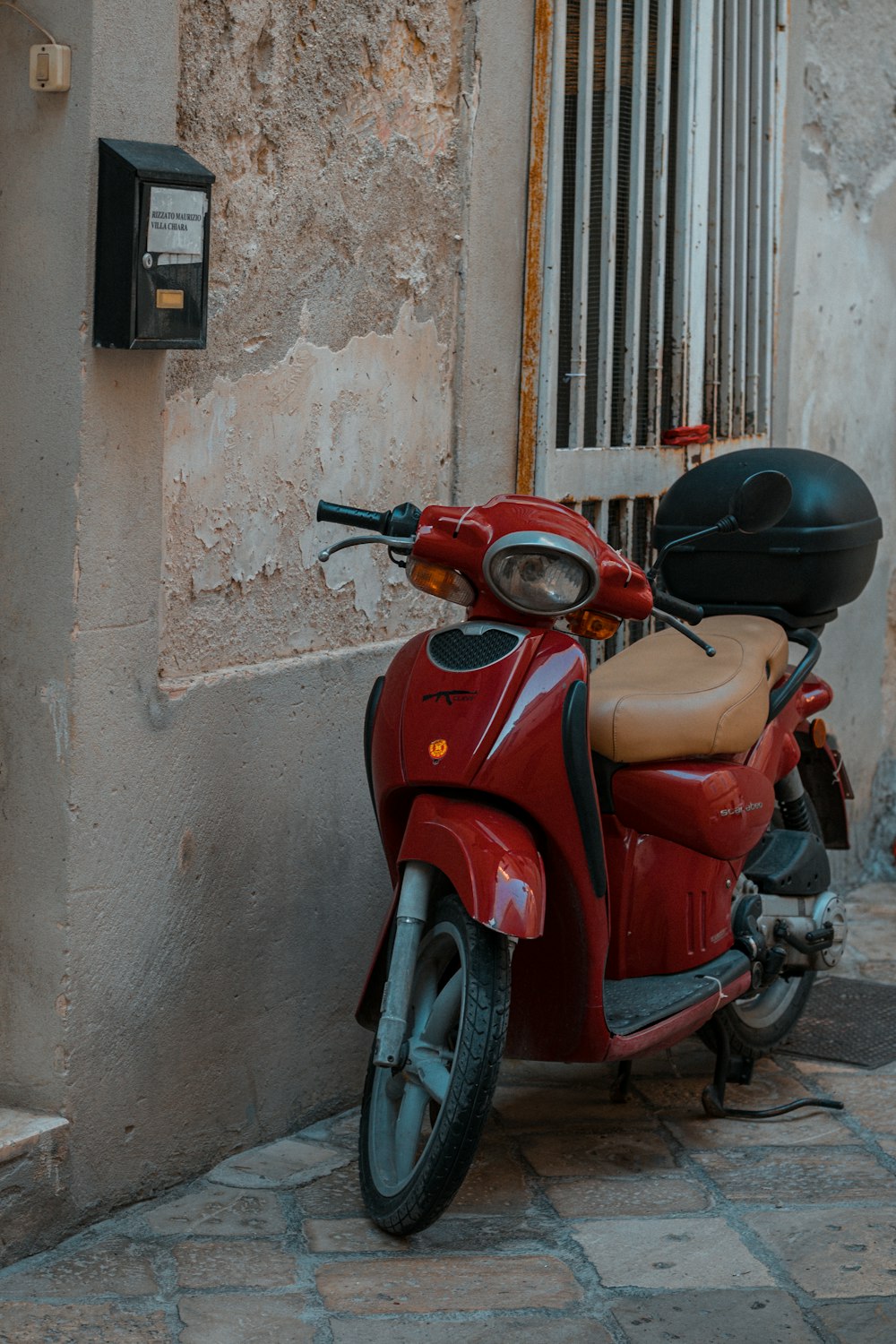 a red motorcycle parked next to a building