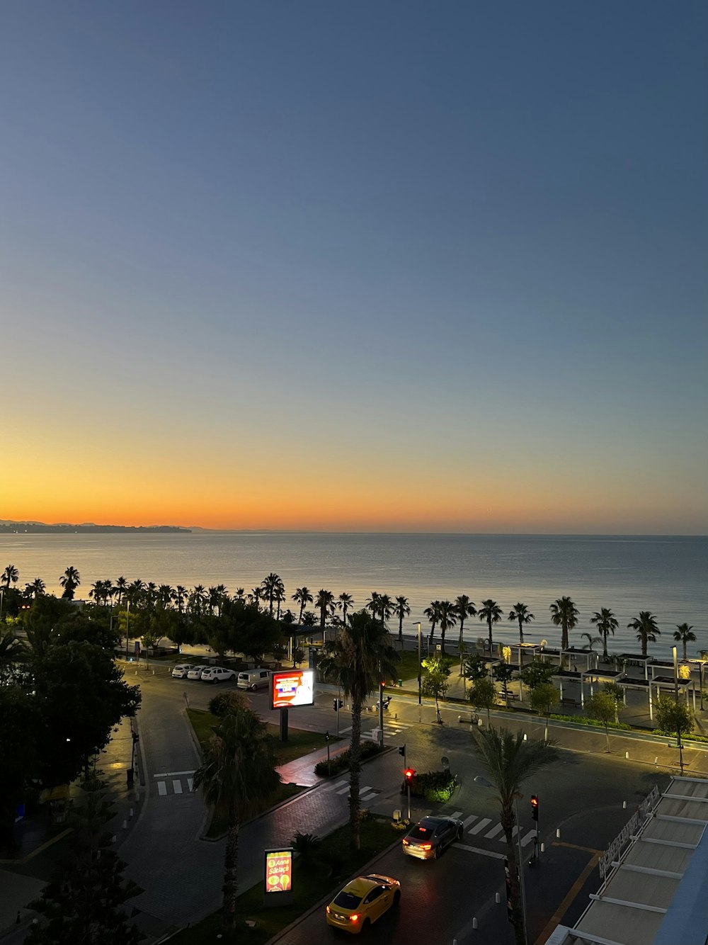 Una calle con coches y árboles junto al agua