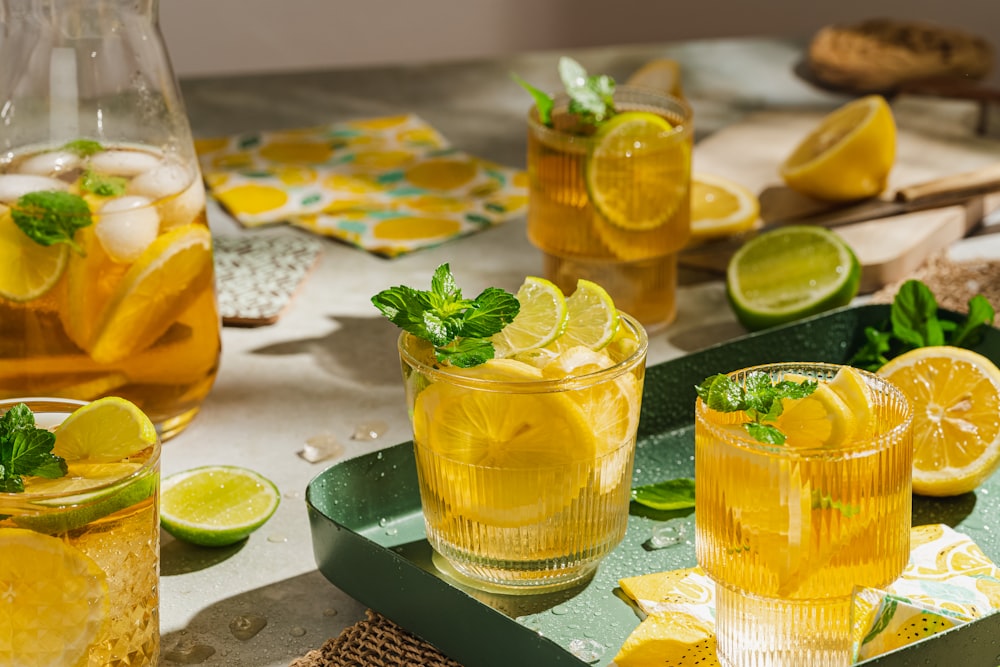 a group of glasses with lemons and limes in them