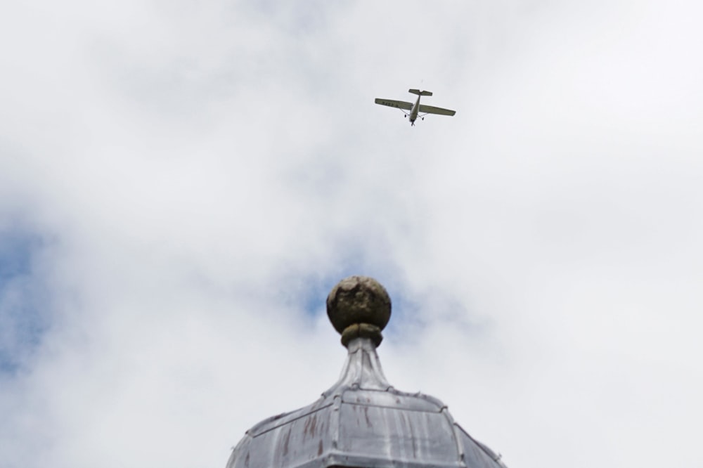 a statue with a plane in the background