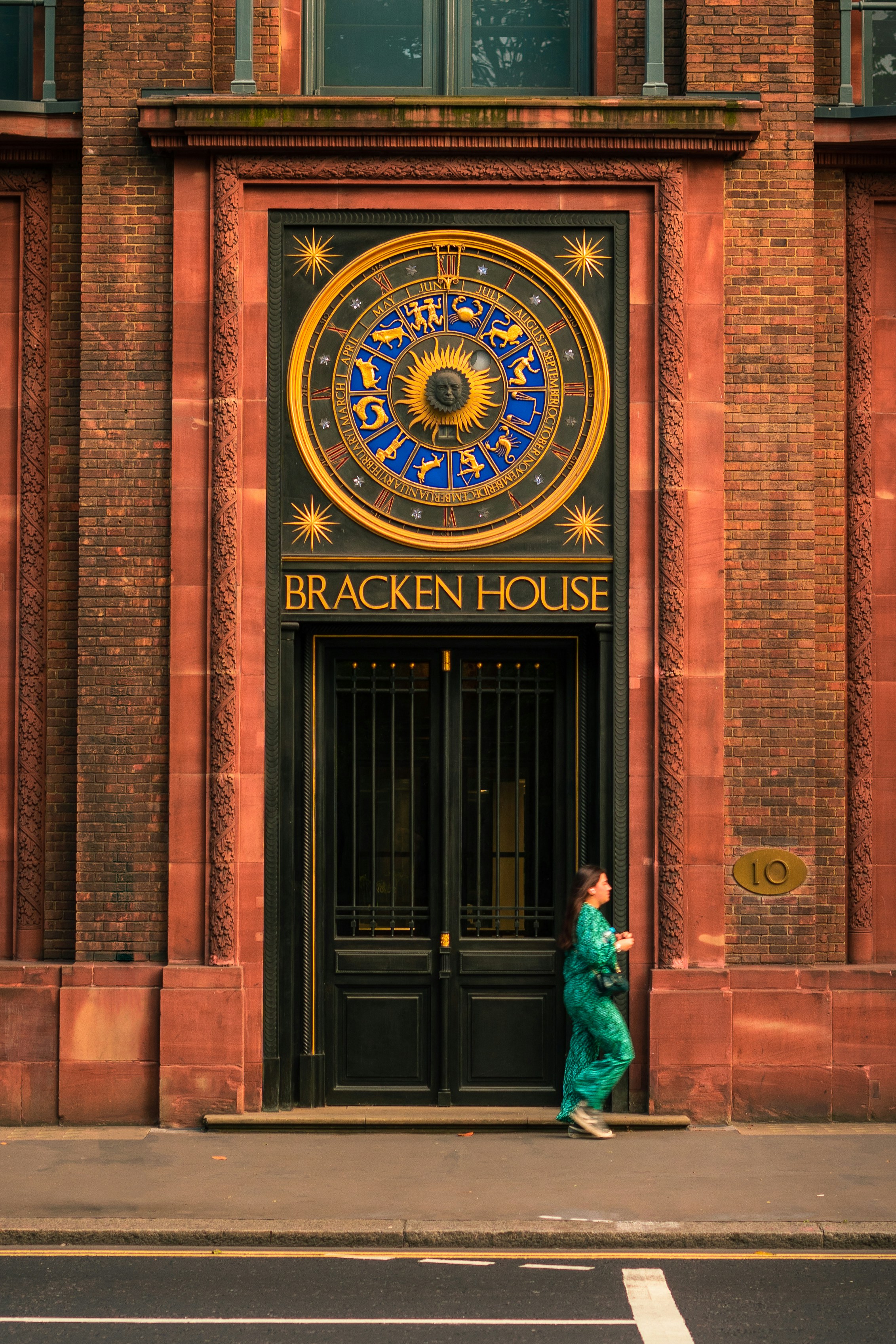 eine Person, die vor einem Gebäude mit einer großen Uhr steht