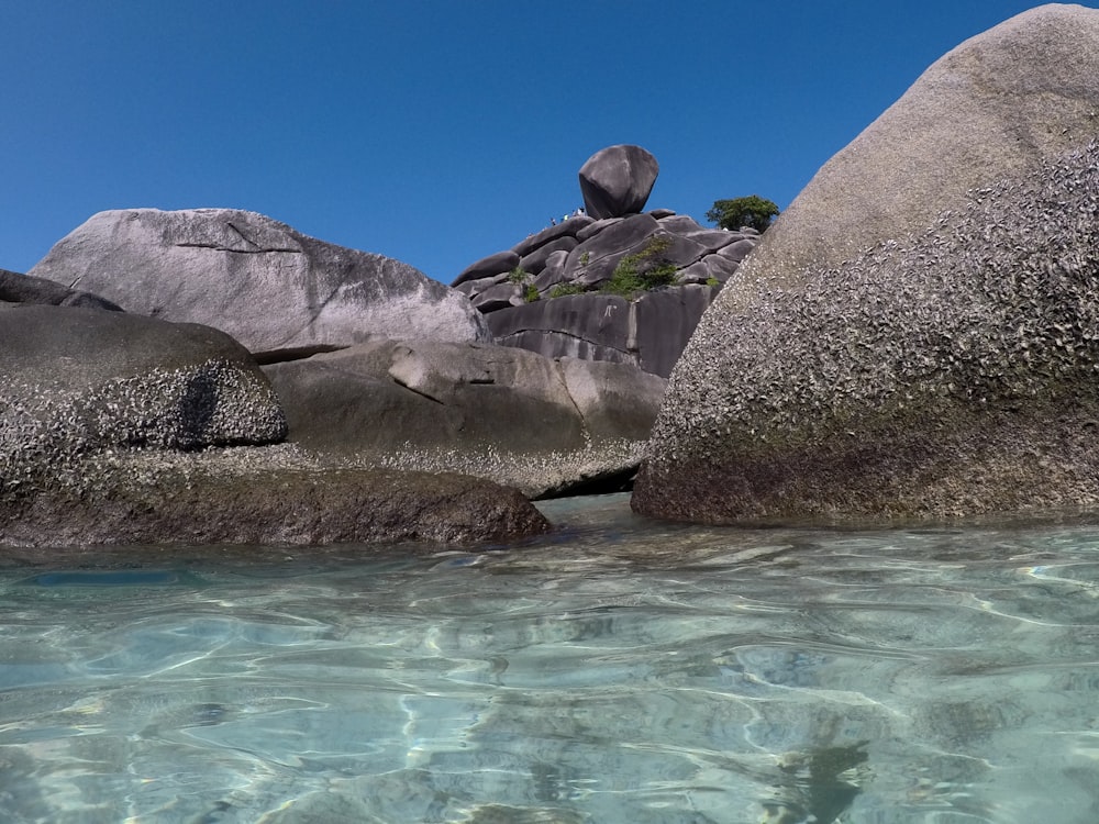 a group of large rocks by water