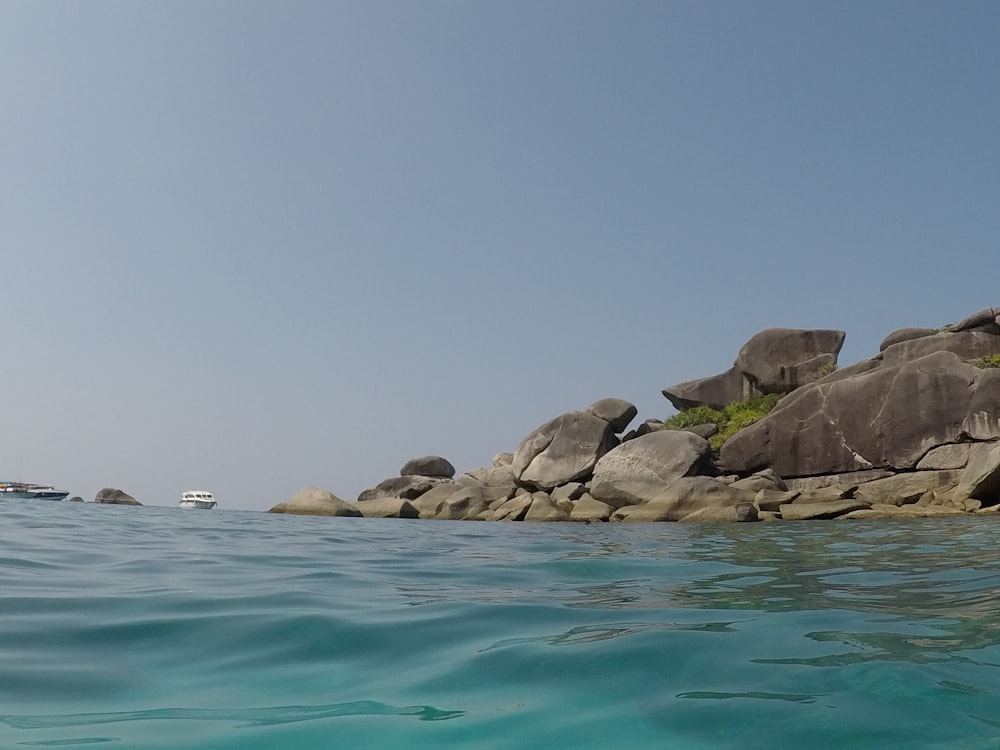 a rocky shoreline with a boat in the water