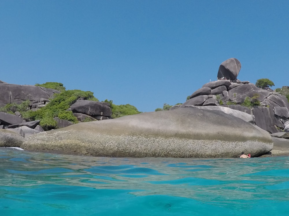 a group of rocks in the water with Similan Islands in the background