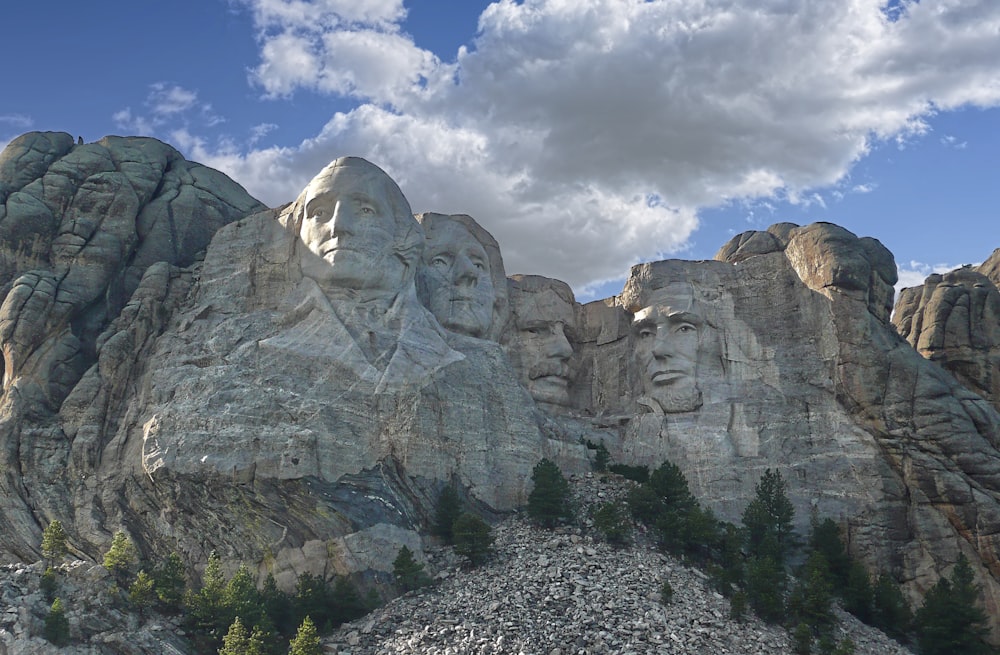 une grande formation rocheuse avec le Mémorial national du Mont Rushmore en arrière-plan