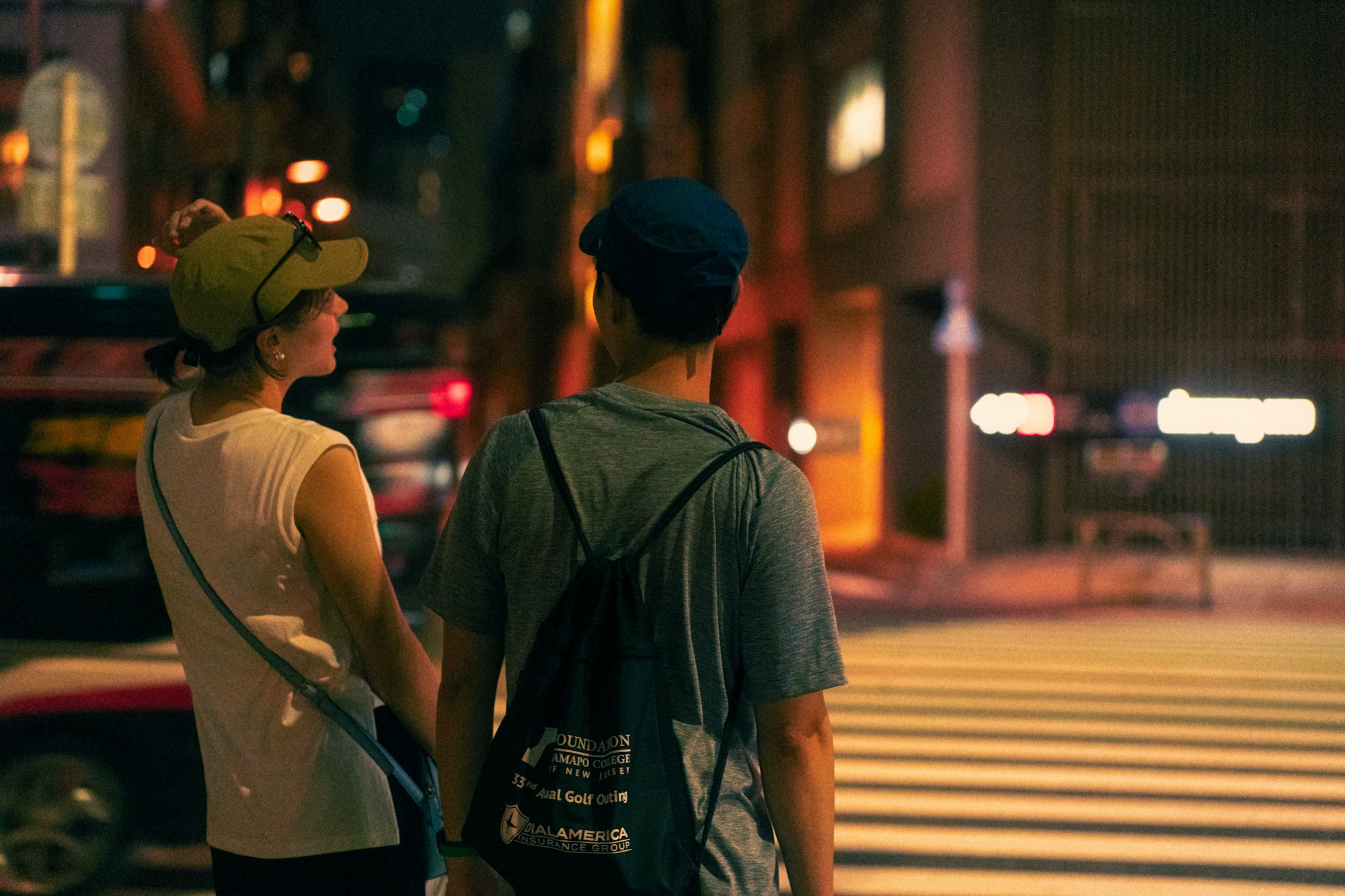 a man and woman walking on a street at night